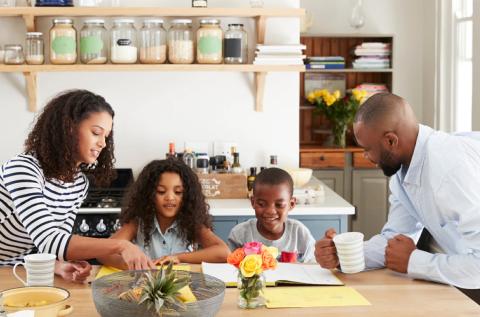 A family of four sitting at a kitchen table together